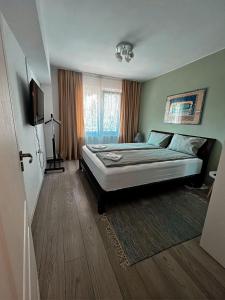ein Schlafzimmer mit einem großen Bett in einem Zimmer in der Unterkunft Green Apartament in Sovata