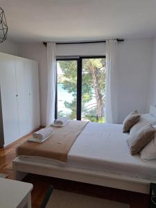 a bedroom with a large bed with a large window at Guesthouse Tamara in Lovište
