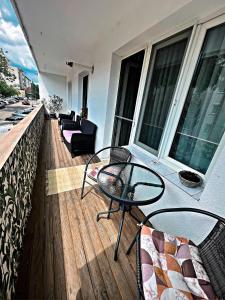 einen Balkon mit einem Tisch und Stühlen auf einem Gebäude in der Unterkunft Green Apartament in Sovata