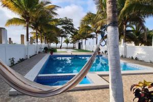 a hammock hanging from a palm tree next to a pool at Casa de playa Palmeras in Tumbes