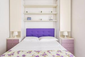 Stella Marina في سيلا: سرير مع اللوح الأمامي الأرجواني في غرفة النوم