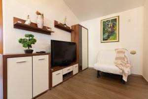 ein Wohnzimmer mit einem TV und einem Stuhl in der Unterkunft Holiday house Hana in Rovinj