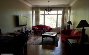 a living room with a red couch and a tv at Bostanci cozy excellent location flat in Istanbul