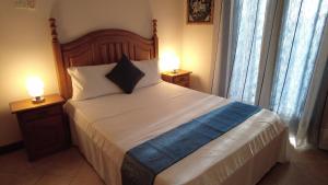 1 dormitorio con 1 cama grande y 2 lámparas en las mesas en Residence Abrico en Mont Choisy