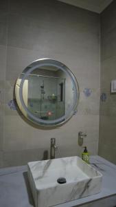 y baño con lavabo blanco y espejo. en Residence Abrico en Mont Choisy