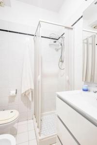 a white bathroom with a shower and a toilet at Stella Marina in Scilla