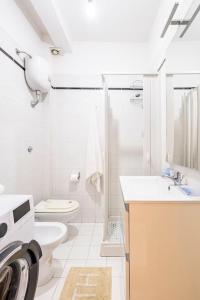 La salle de bains blanche est pourvue de toilettes et d'un lavabo. dans l'établissement Stella Marina, à Scilla