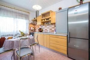 La cuisine est équipée d'une table et d'un réfrigérateur en acier inoxydable. dans l'établissement Home away from home, à Šmrika
