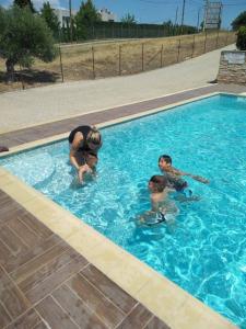 a woman and two children in a swimming pool at Delmare Olive beach house II in Yerakiní