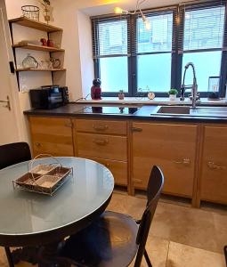 - une cuisine avec une table, des chaises et un évier dans l'établissement Studio Calme Hyper Centre Brive, à Brive-la-Gaillarde