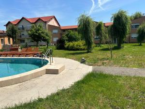 - une piscine avec bancs à côté d'un bâtiment dans l'établissement Venus Resort, à Uisenteş