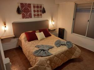 a bedroom with a bed with a robe on it at Departamento dos dormitorios con cochera Tres Arroyos -2- in Tres Arroyos