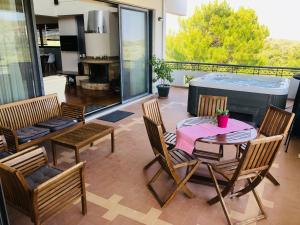a patio with a table and chairs and a hot tub at Elena's Country Home & SPA in Kalithies