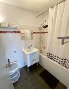 La salle de bains est pourvue d'un lavabo, d'une baignoire et de toilettes. dans l'établissement T2 Parc Belvédère, à Montpellier
