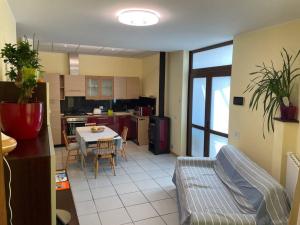 Casa vacanze LILLY في Germignaga: مطبخ وغرفة معيشة مع أريكة وطاولة