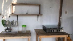 a kitchen with two wooden tables and a stove at Pangora, habitación privada de Flor de Lis Beach House in Playas