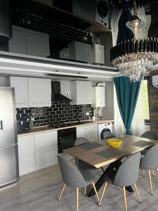 LuminaApartament Maya Lumina的配有木桌和椅子的厨房