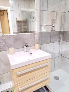 a bathroom with a white sink and a shower at Tottenham Spur Hideaway in London