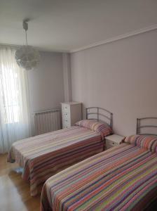 1 dormitorio con 2 camas con sábanas a rayas en Eras, en Elciego