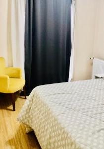 ein Schlafzimmer mit einem Bett und einem gelben Stuhl in der Unterkunft Full 2 bedroom apartment in luxury complex in Esenyurt