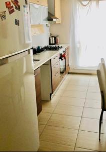 eine Küche mit einem weißen Kühlschrank und Fliesenboden in der Unterkunft Full 2 bedroom apartment in luxury complex in Esenyurt