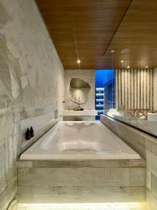 巴西利亞的住宿－Yolo Motel，石墙浴室内的大型浴缸