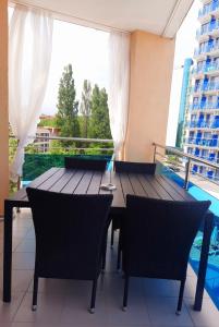 einen Balkon mit einem Holztisch und Stühlen in der Unterkunft Apartment "Palace" in Sonnenstrand