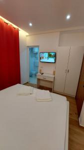 sypialnia z białym łóżkiem i telewizorem na ścianie w obiekcie Rinia Apartments w Ulcinju