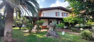 a house with a palm tree in front of it at Elisa Holidays in Puegnano del Garda