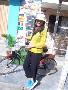 a woman is standing next to a bike at POSADA MIS 3 BENDICIONES in Paracas