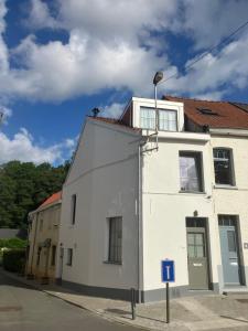 a white building on the side of a street at La Maison des Sources in Brussels