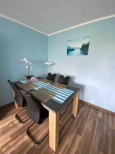 mesa de comedor con sillas negras y pared azul en Apartament przy Parku Śląskim, en Katowice