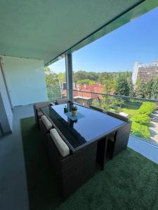 salon ze stołem i dużym oknem w obiekcie Mistral Helka Apartman w Balatonföldvárze