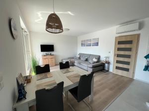 a living room with a table and a couch at Mistral Helka Apartman in Balatonföldvár