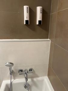 łazienka z dwoma kubkami na ścianie nad umywalką w obiekcie Mistral Helka Apartman w Balatonföldvárze