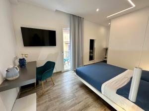 a bedroom with a bed and a desk and a television at B&B Altomare in Lampedusa +19 photos