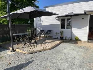 a patio with a table and chairs and an umbrella at Petite maison à la mer in Sassetot-le-Mauconduit