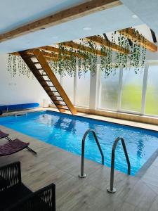 een groot zwembad in een gebouw met ramen bij Villa Nature in Bihać
