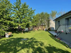 a yard with green grass and trees next to a house at Ferienhaus Herger in Niendorf