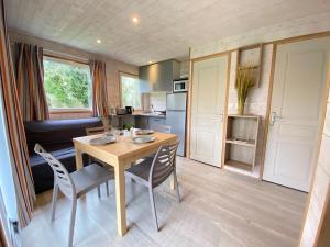 a kitchen and dining room with a table and chairs at Camping la Venise Verte in Coulon