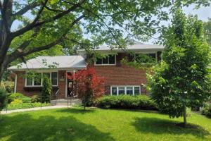 a red brick house with a tree in the yard at 5 bedroom w/ indoor pool/hotub in Silver Spring