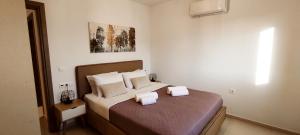 a bedroom with a bed with two towels on it at EZITH LUXURY APARTMENTS in Heraklio Town