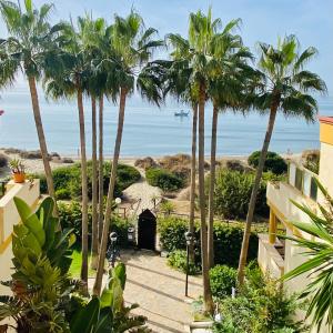una casa con palmeras y vistas a la playa en Super2beachfront, en Marbella