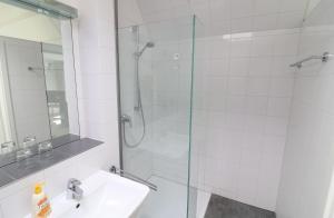 La salle de bains est pourvue d'un lavabo et d'une douche en verre. dans l'établissement Ferienwohnung- modernes Apartment in Barth am Bodden, à Barth