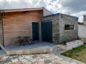 um edifício de tijolos com uma porta preta e uma mesa num pátio em Cabanon Fabrin em Saint-Mitre-les-Remparts