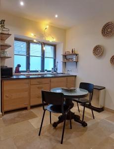 een keuken met een tafel en stoelen en een wastafel bij Studio Calme Hyper Centre Brive in Brive-la-Gaillarde