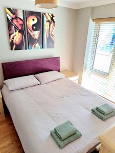 a bedroom with a bed with two towels on it at Tottenham Spur Hideaway in London