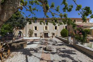 a courtyard in front of a large white building at Chambres & Tables d'hôtes Moulin de Lavon in Gargas