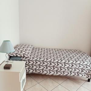 un letto con piumone bianco e nero in una stanza di B&B Bella Notte a Montesilvano