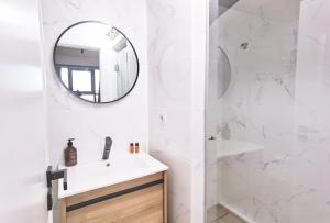 uma casa de banho branca com um lavatório e um espelho em Ninho 424 no Porto